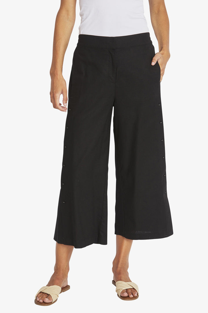 Person wearing black wide-leg pants on a white background