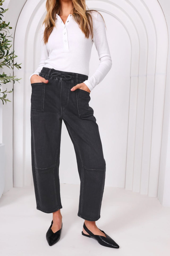 Close-up of the Leo Barrel Jeans in black denim from Ivy Vibe, showing textured stretch fabric and detailed stitching near the pocket and waistband