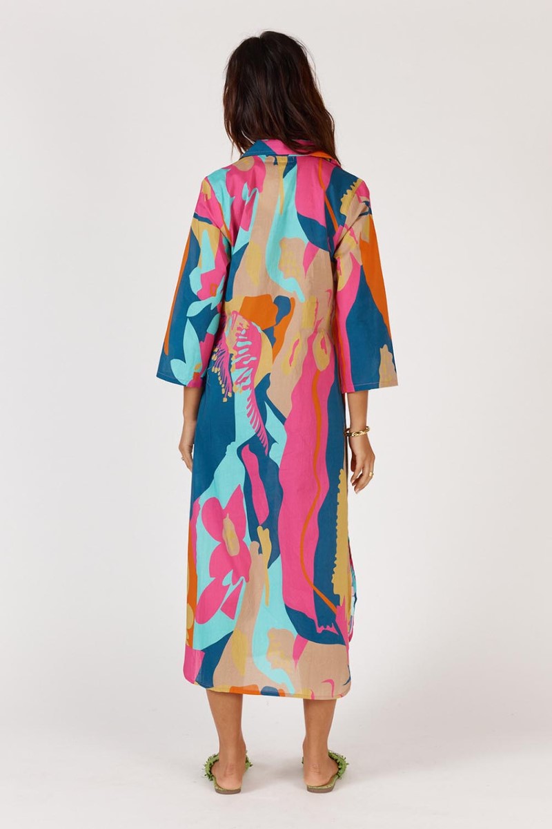 Woman wearing a colorful dress with abstract patterns on a white background