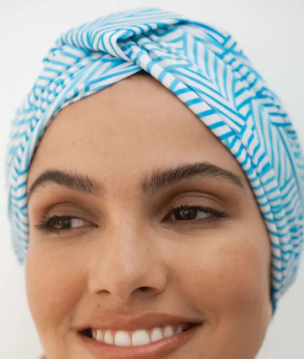 Woman wearing a blue and white patterned headscarf on a white background