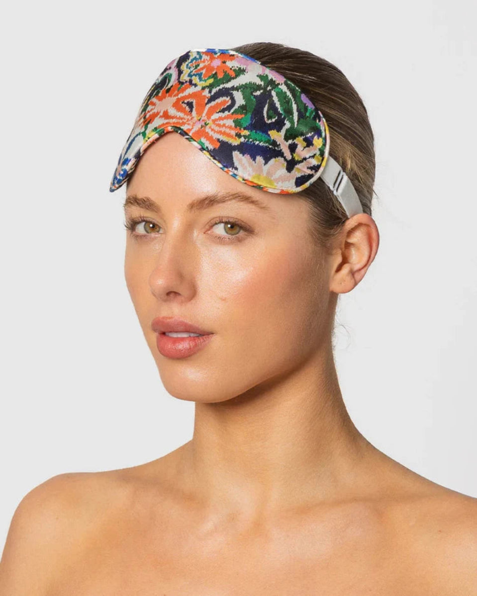 Woman wearing a colorful floral headband on a plain background
