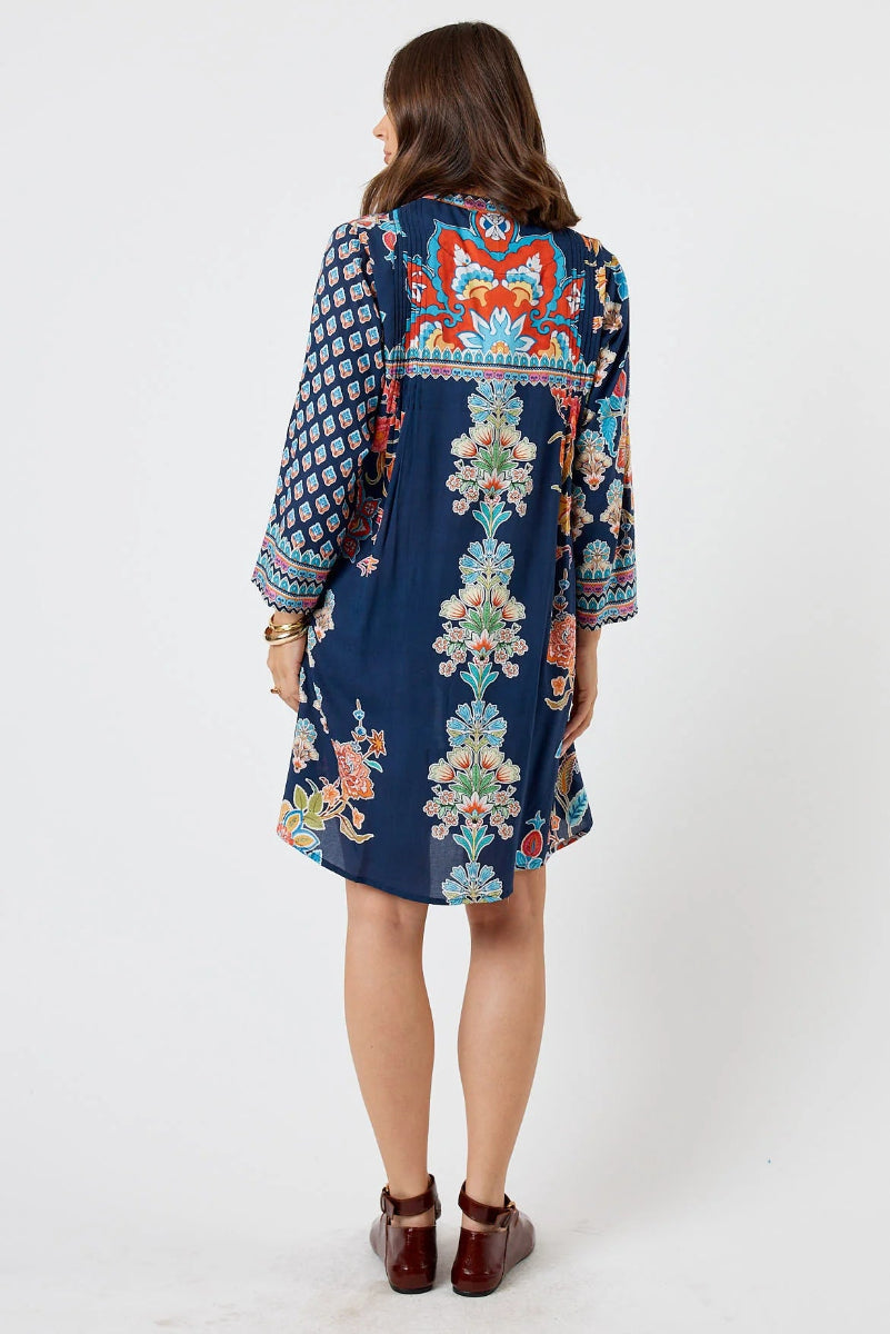 Woman wearing a patterned dress with a white background