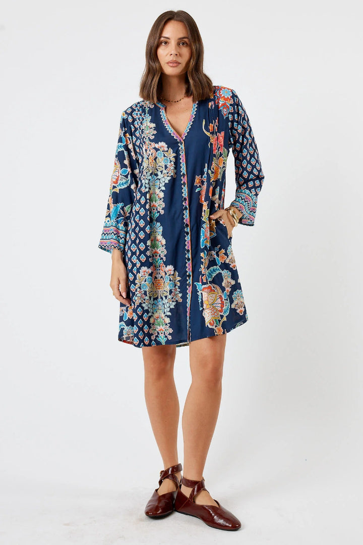 Woman wearing a patterned dress on a white background