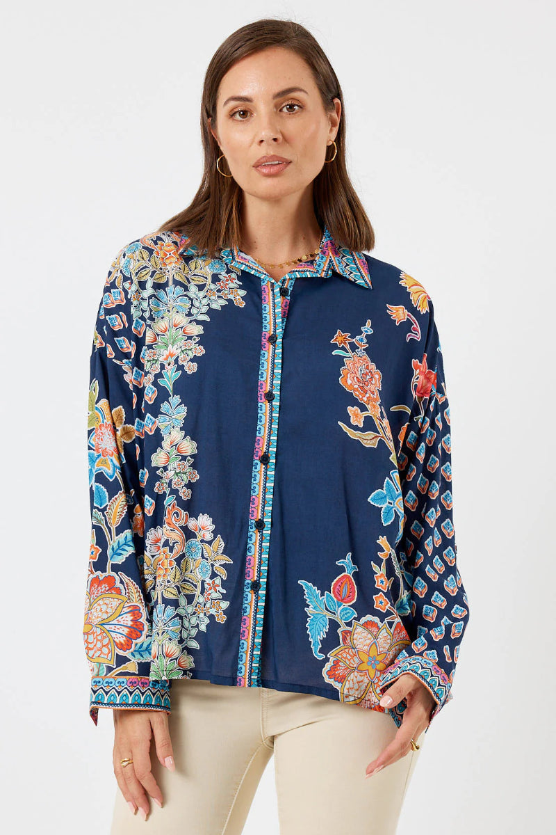 Woman wearing a navy floral blouse on a white background