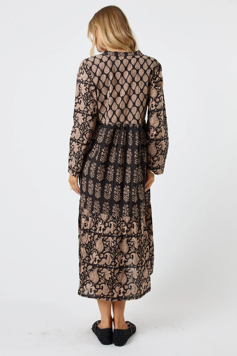 Woman wearing a long, black lace dress on a white background