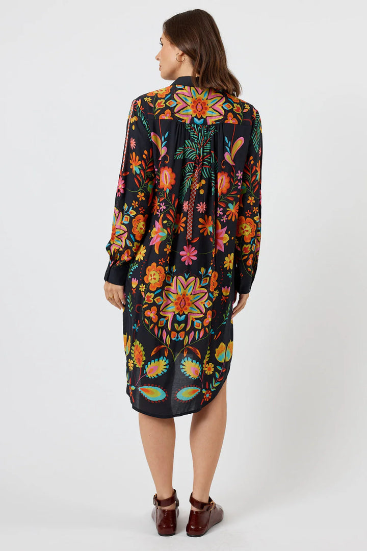 Woman wearing a colorful floral dress on a white background