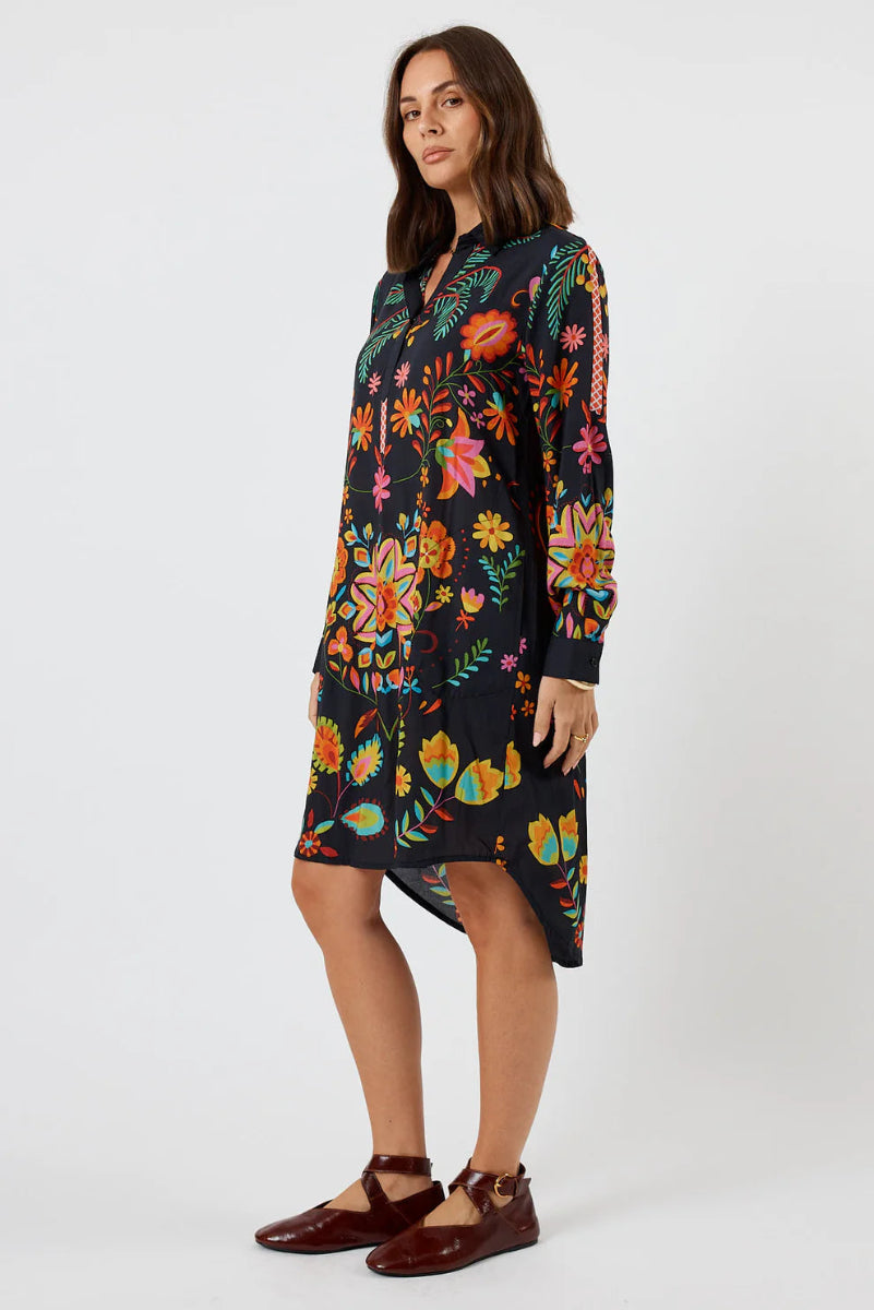 Woman wearing a colorful floral dress on a white background