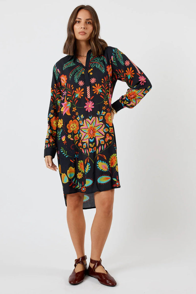 Woman wearing a colorful floral dress on a white background