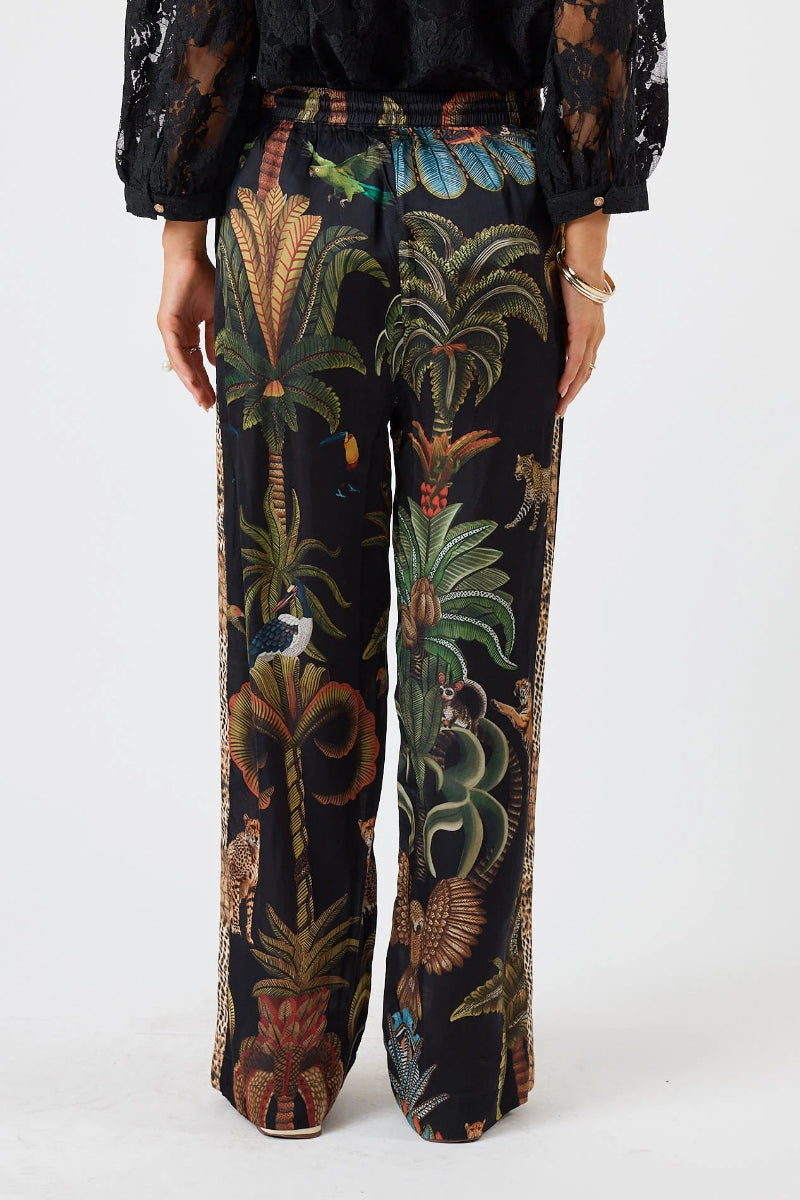 Tropical patterned pants worn by a person on a white background