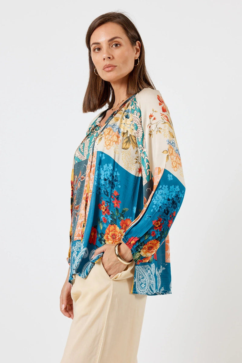 Woman wearing a colorful floral blouse with a white background
