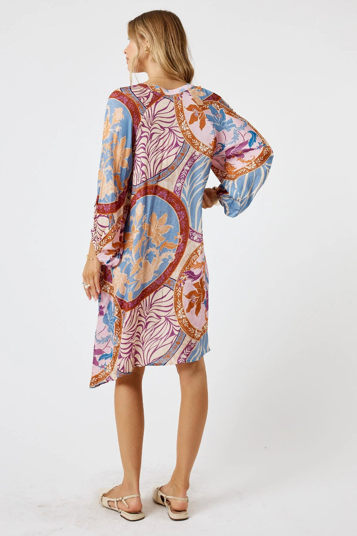 Woman wearing a colorful patterned dress on a white background