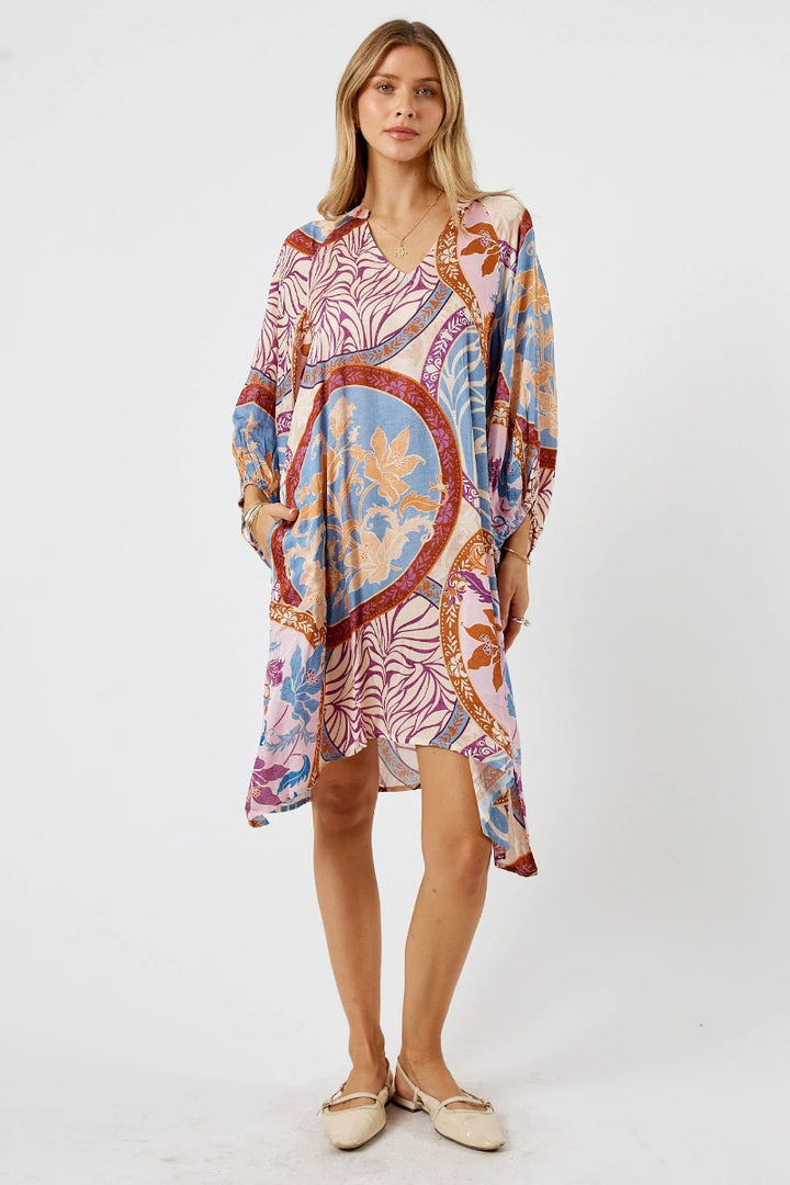 Woman wearing a colorful patterned dress on a white background