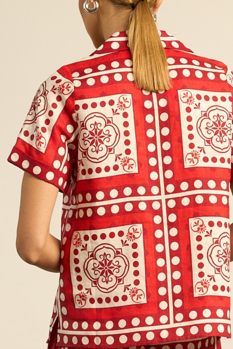 Red and white patterned shirt worn by a person on a beige background
