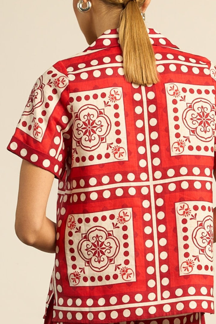 Red and white patterned shirt worn by a person on a beige background