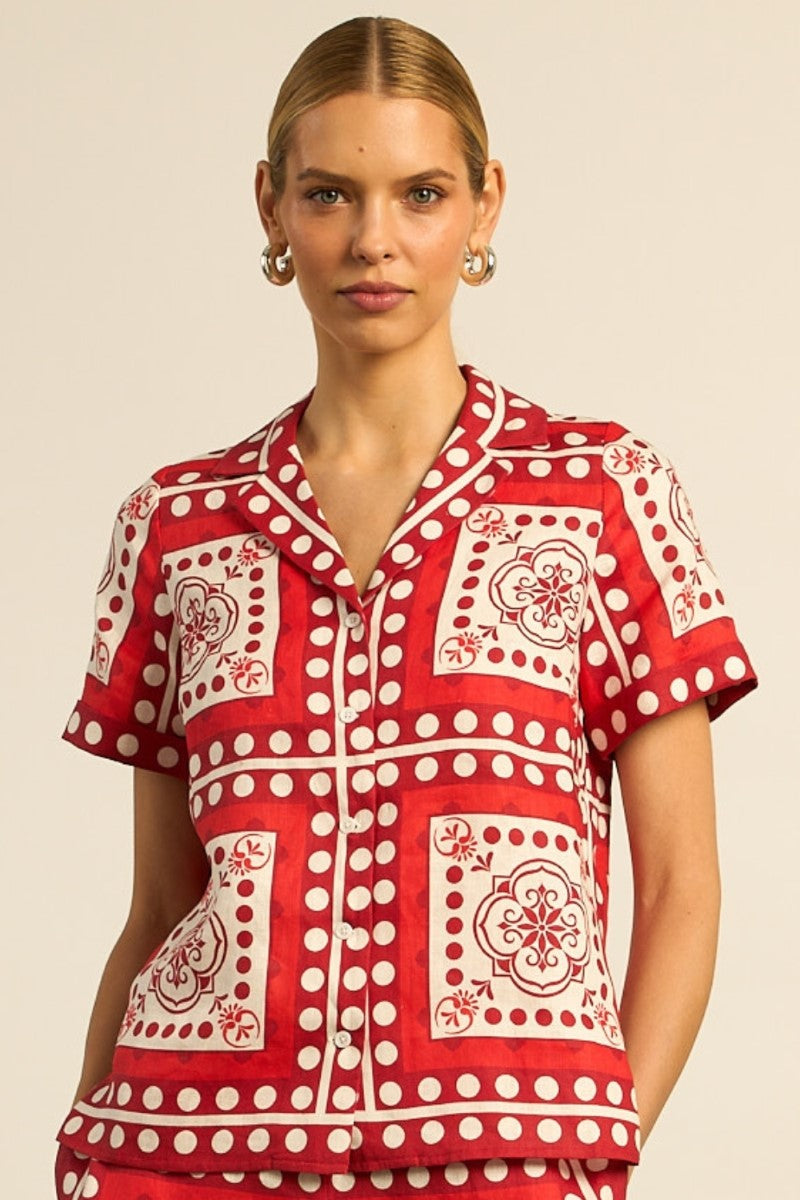 Woman wearing a red and white patterned shirt against a beige background
