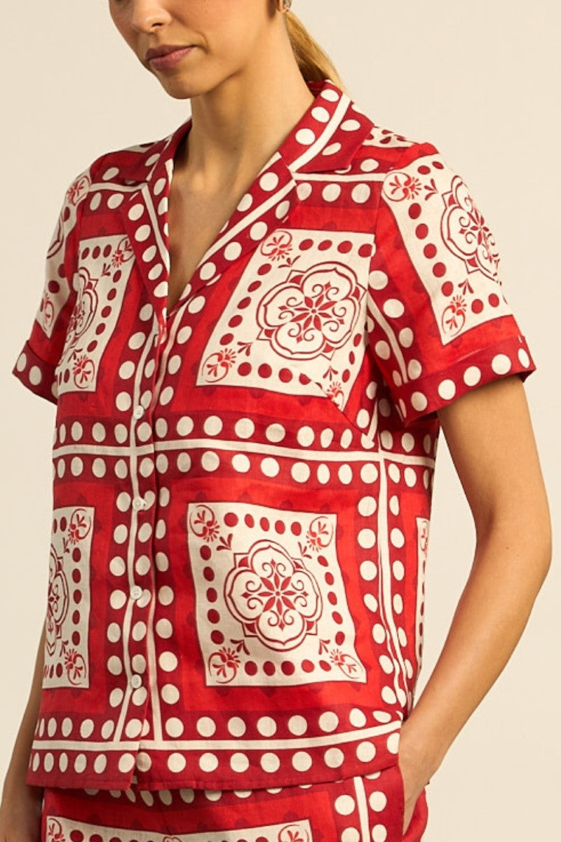 Red and white patterned shirt worn by a person on a beige background