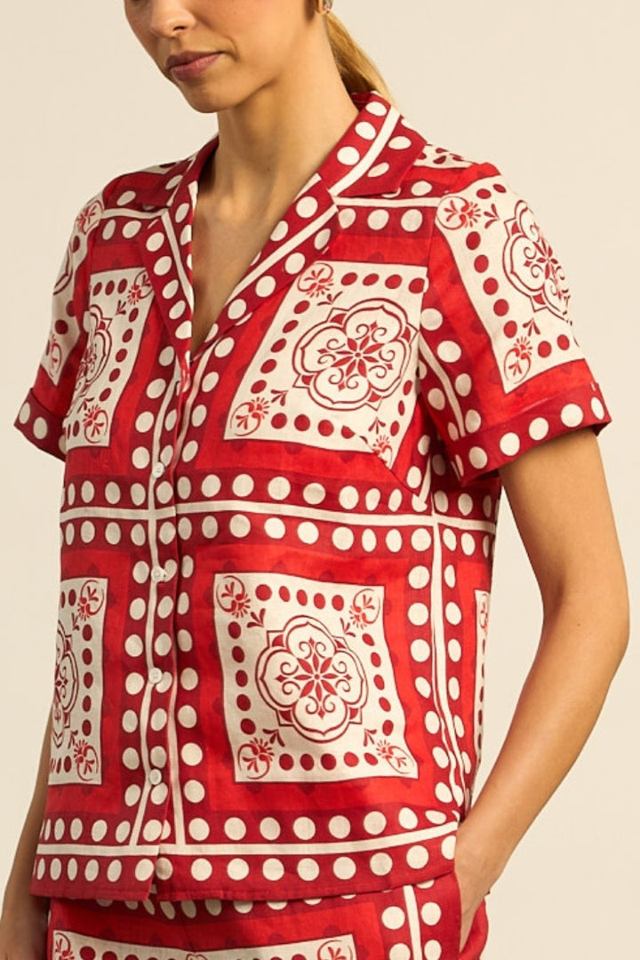 Red and white patterned shirt worn by a person on a beige background