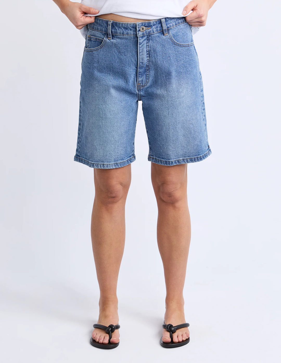 Person wearing blue denim shorts on a white background