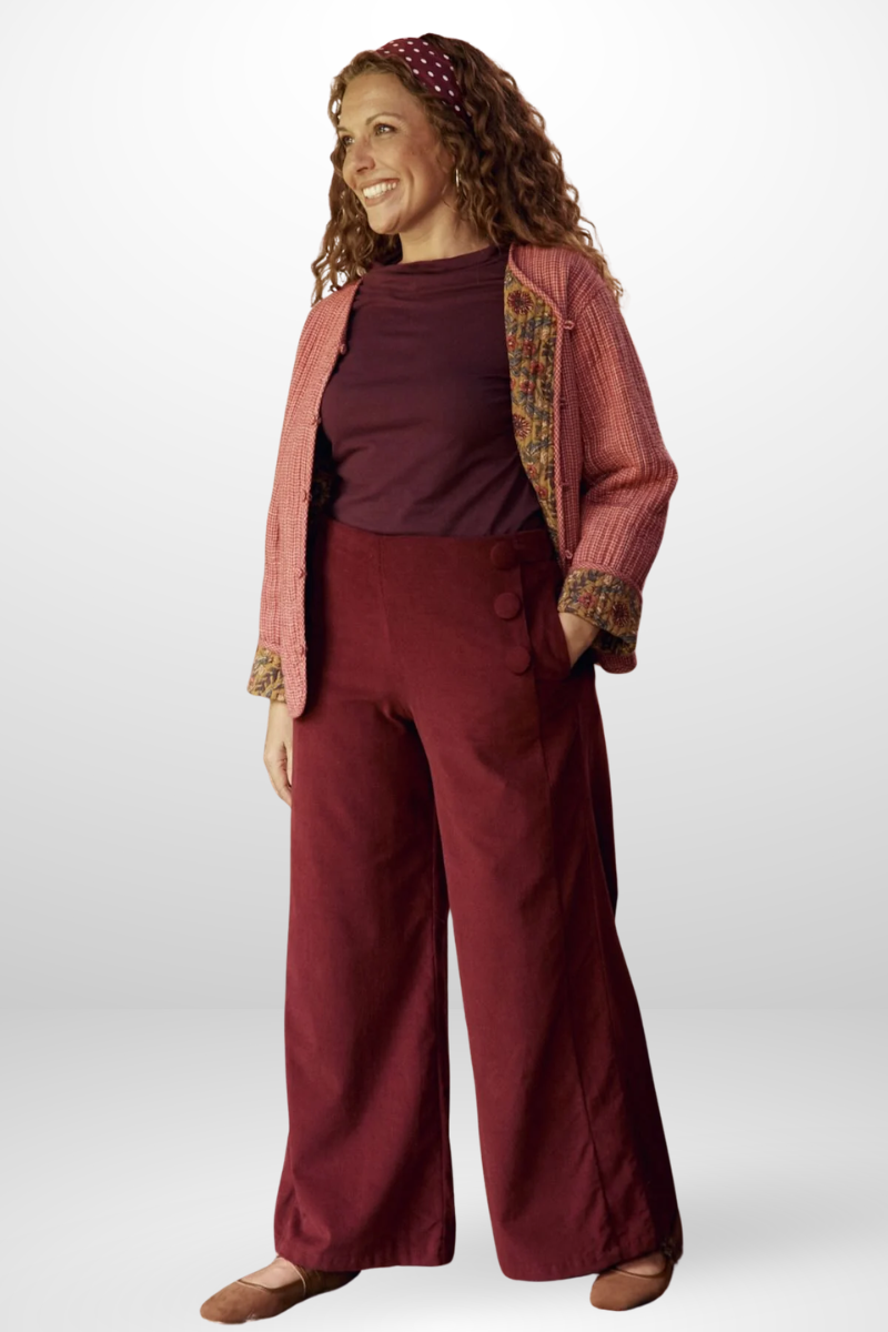 Woman wearing a maroon outfit with a patterned jacket on a white background