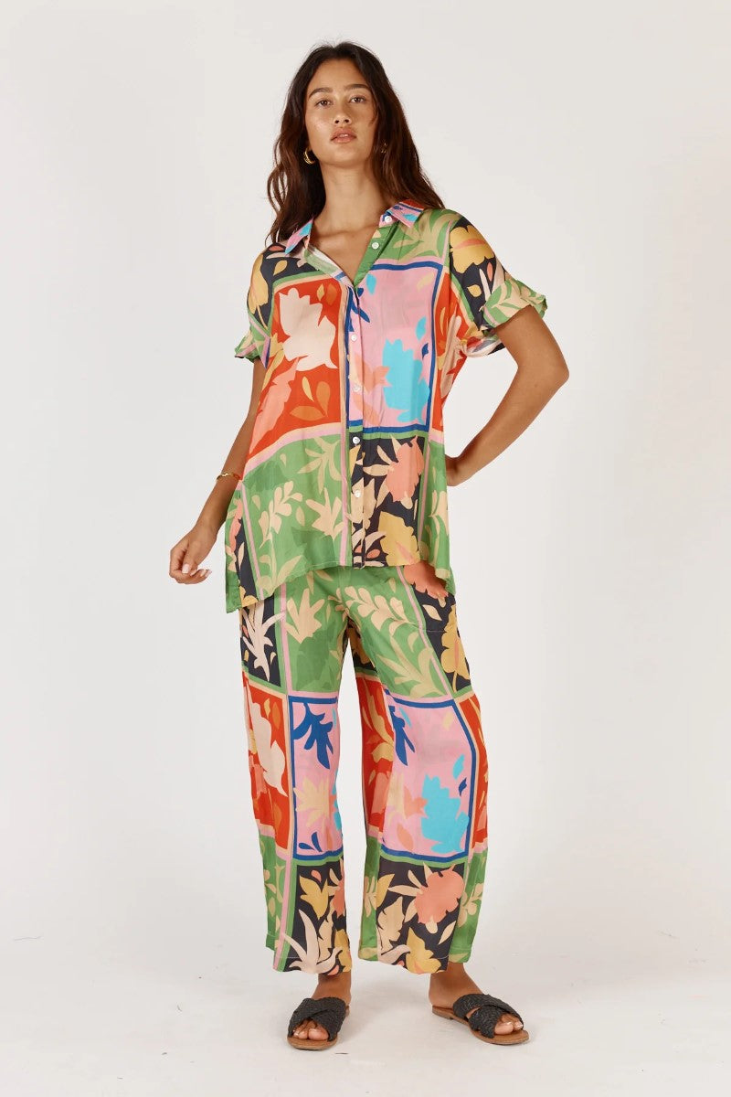 Woman wearing a colorful patterned outfit on a white background