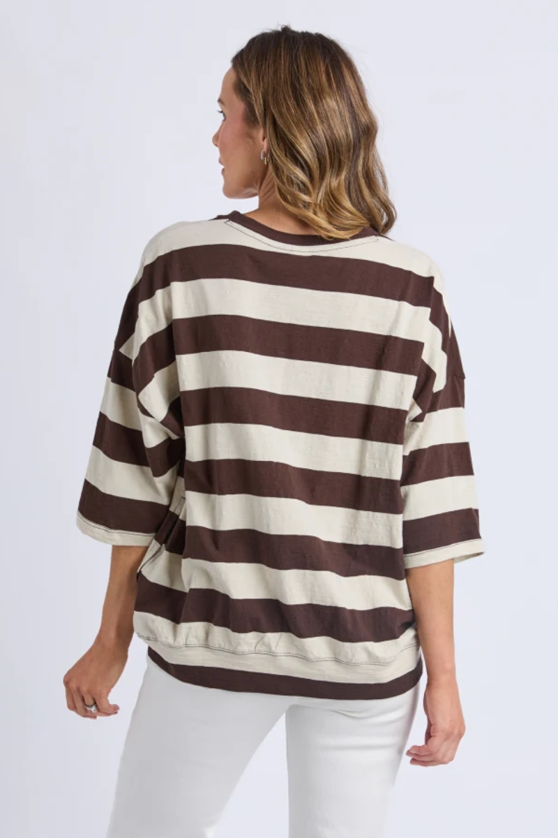 Woman wearing a brown and beige striped sweater on a white background