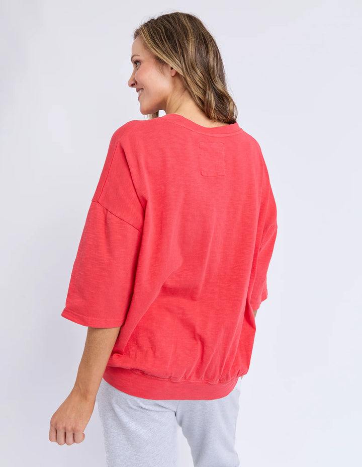 Woman wearing a coral oversized sweatshirt on a white background