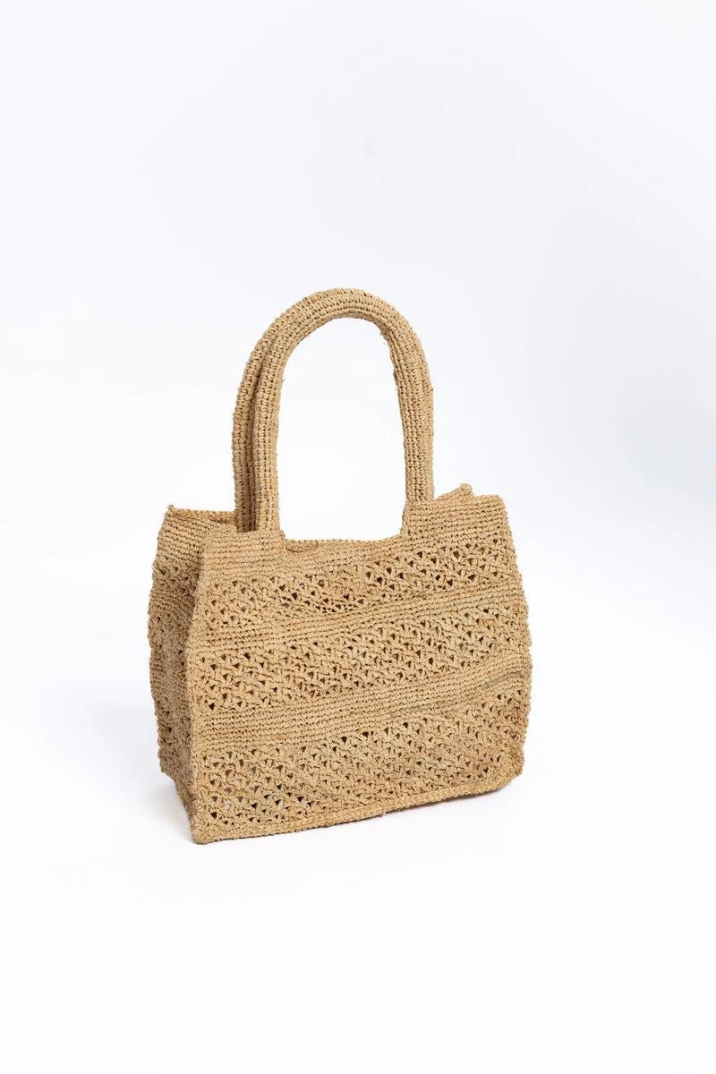 A natural woven straw tote bag with two top handles, shown on a clean white background.