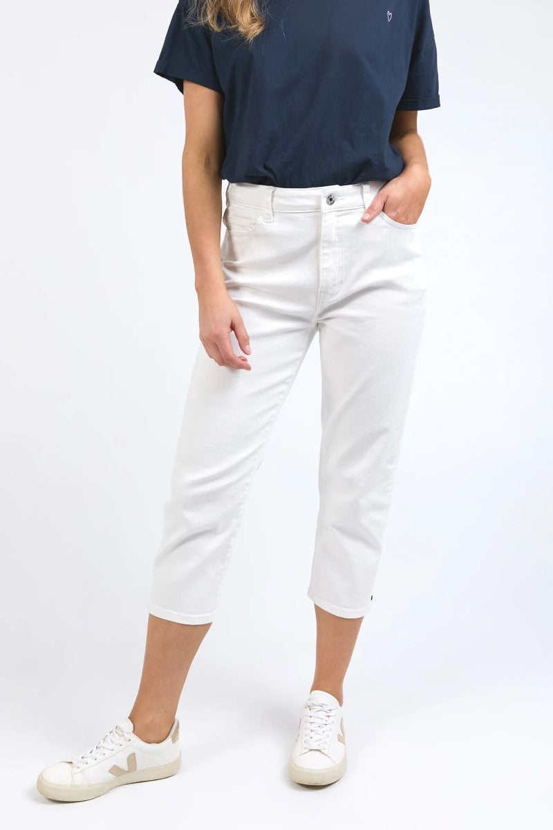 Person wearing a navy t-shirt and white jeans on a white background