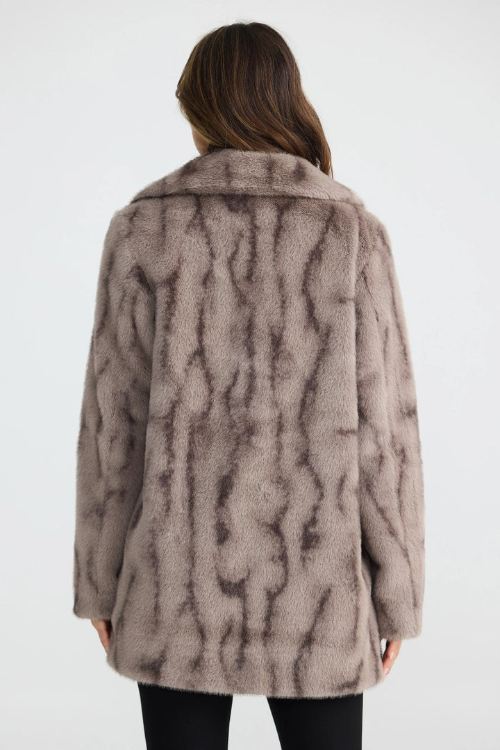 Back view of the Nadia Fur Coat in textured mink, showcasing its mid-thigh length and soft textured faux fur finish