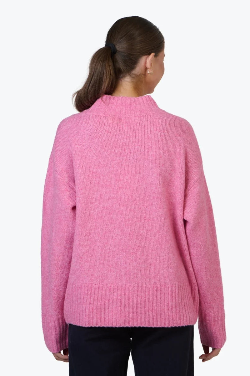 Person wearing a pink sweater on a white background