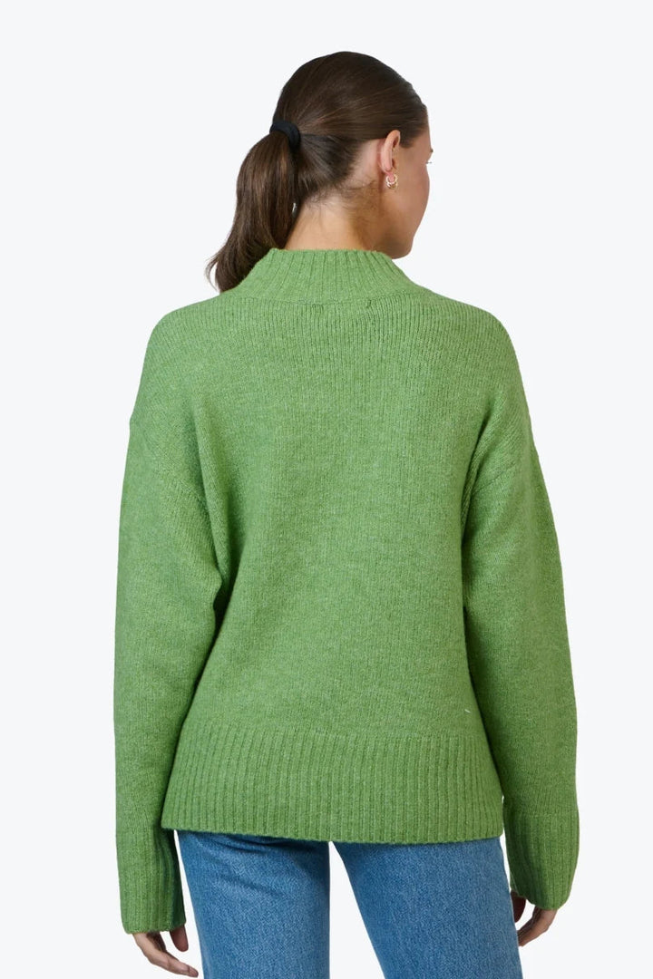 Person wearing a green sweater on a white background