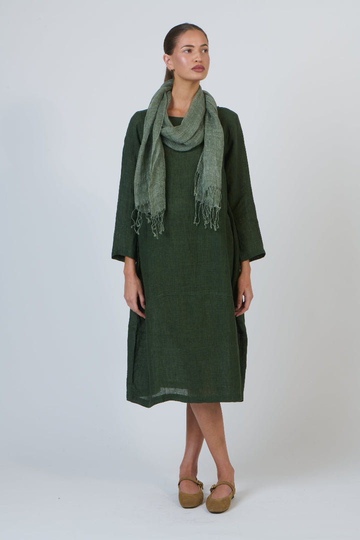 Woman wearing a green dress and scarf on a white background