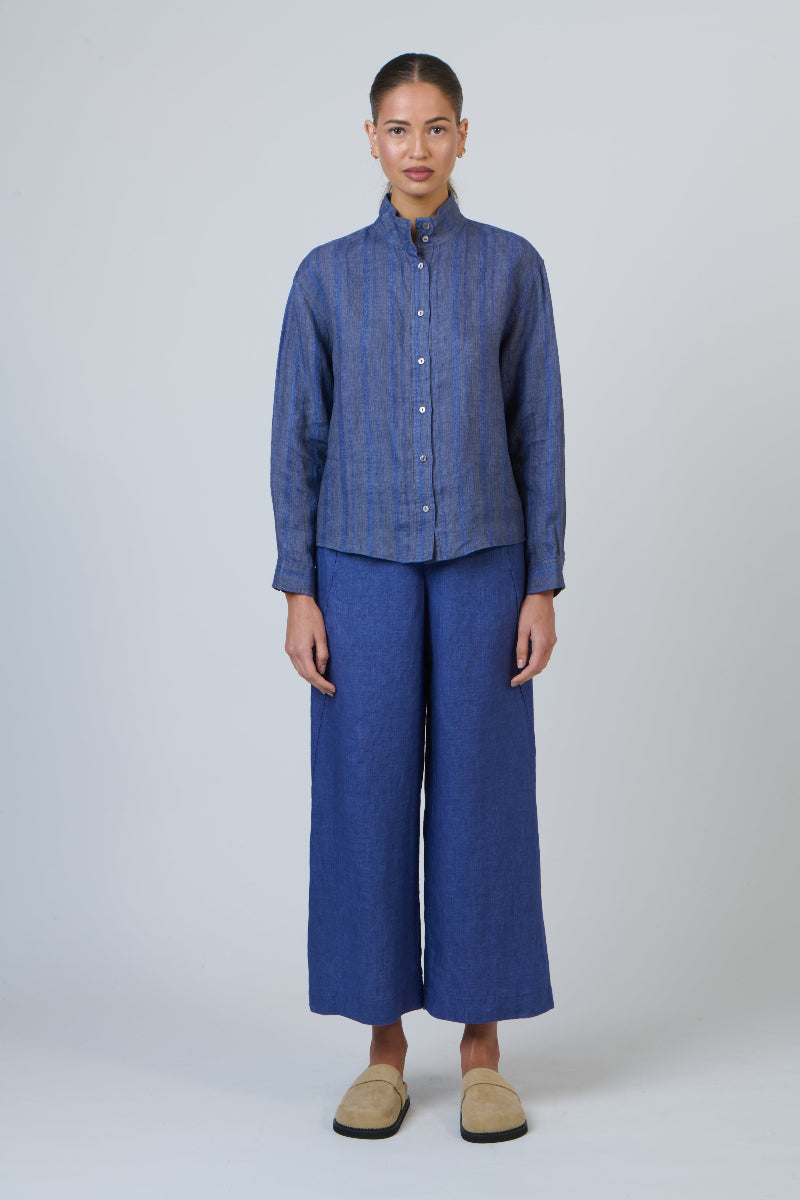 Person wearing a blue outfit with wide-leg pants on a white background