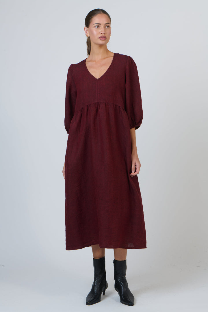 Woman wearing a burgundy dress on a white background