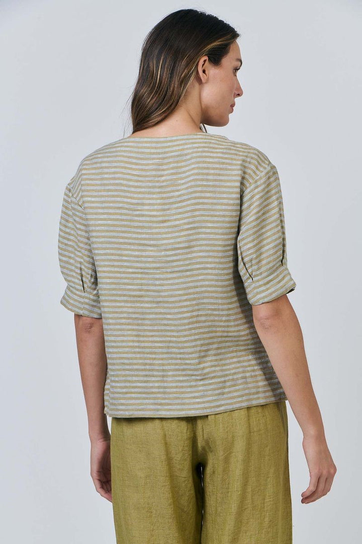 Person wearing a striped shirt and green pants against a plain background
