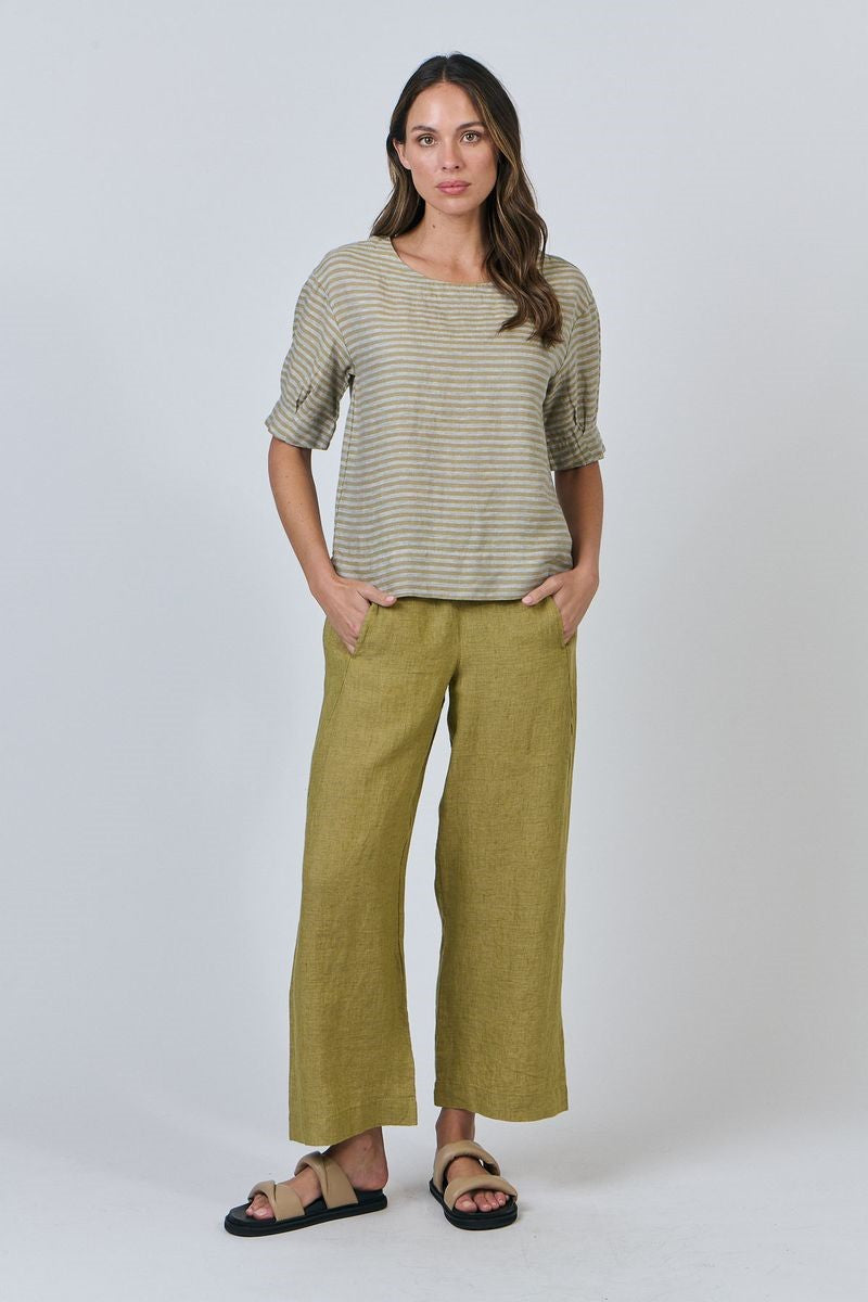 Woman wearing a striped shirt and green pants on a white background