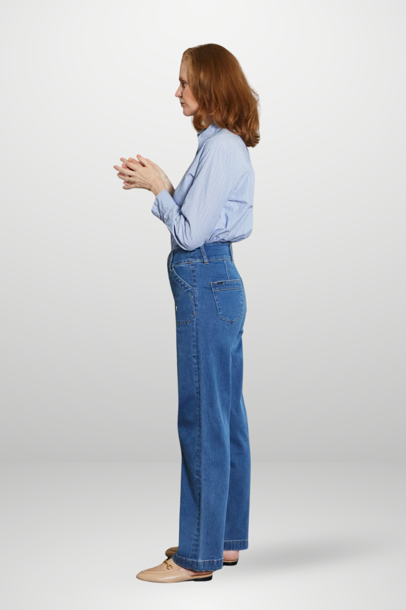 Woman wearing a light blue shirt and blue jeans on a white background