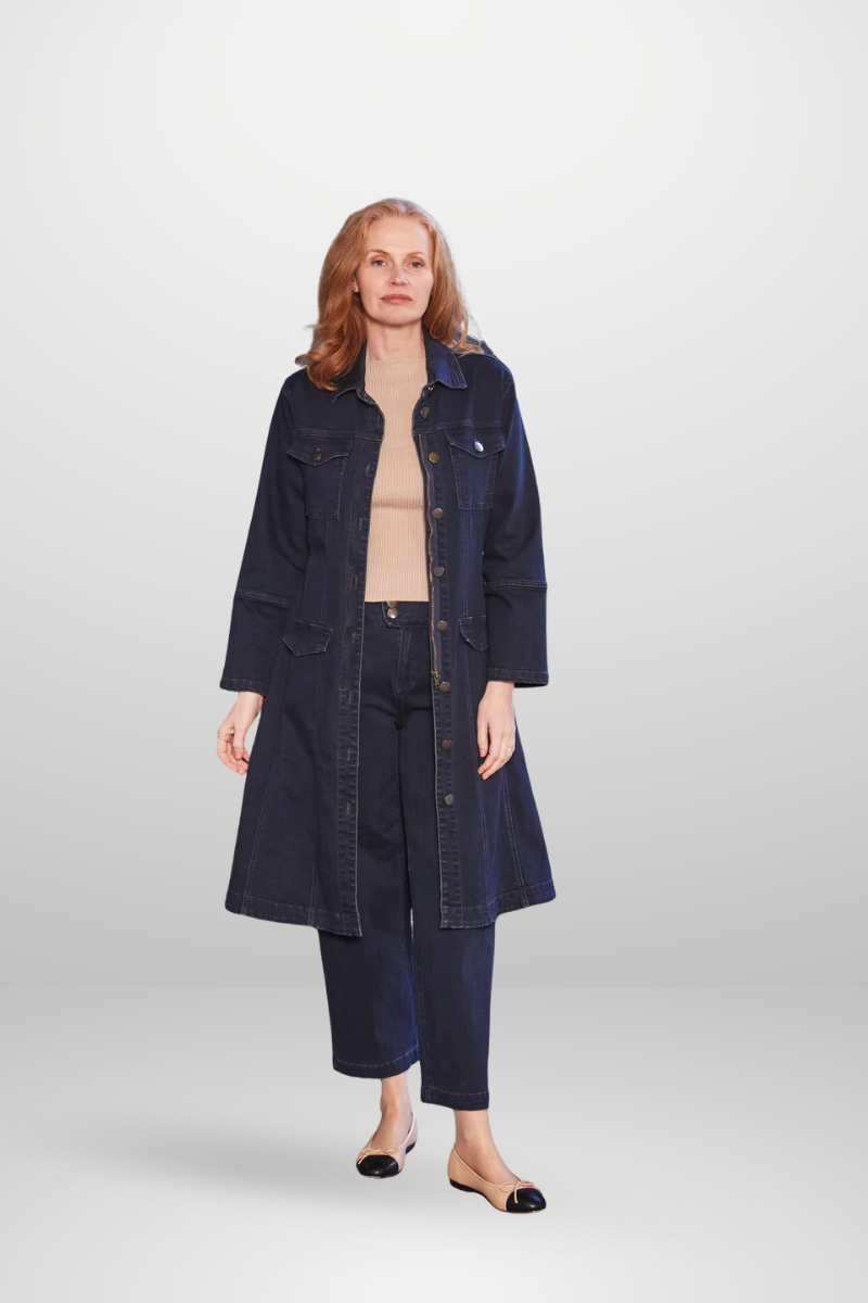 Woman wearing a long denim coat and jeans on a white background