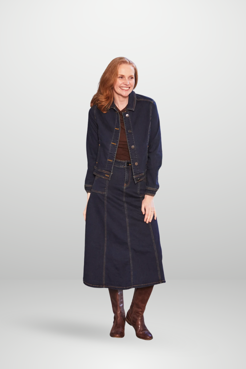 Woman wearing a dark denim outfit with a jacket and skirt on a white background