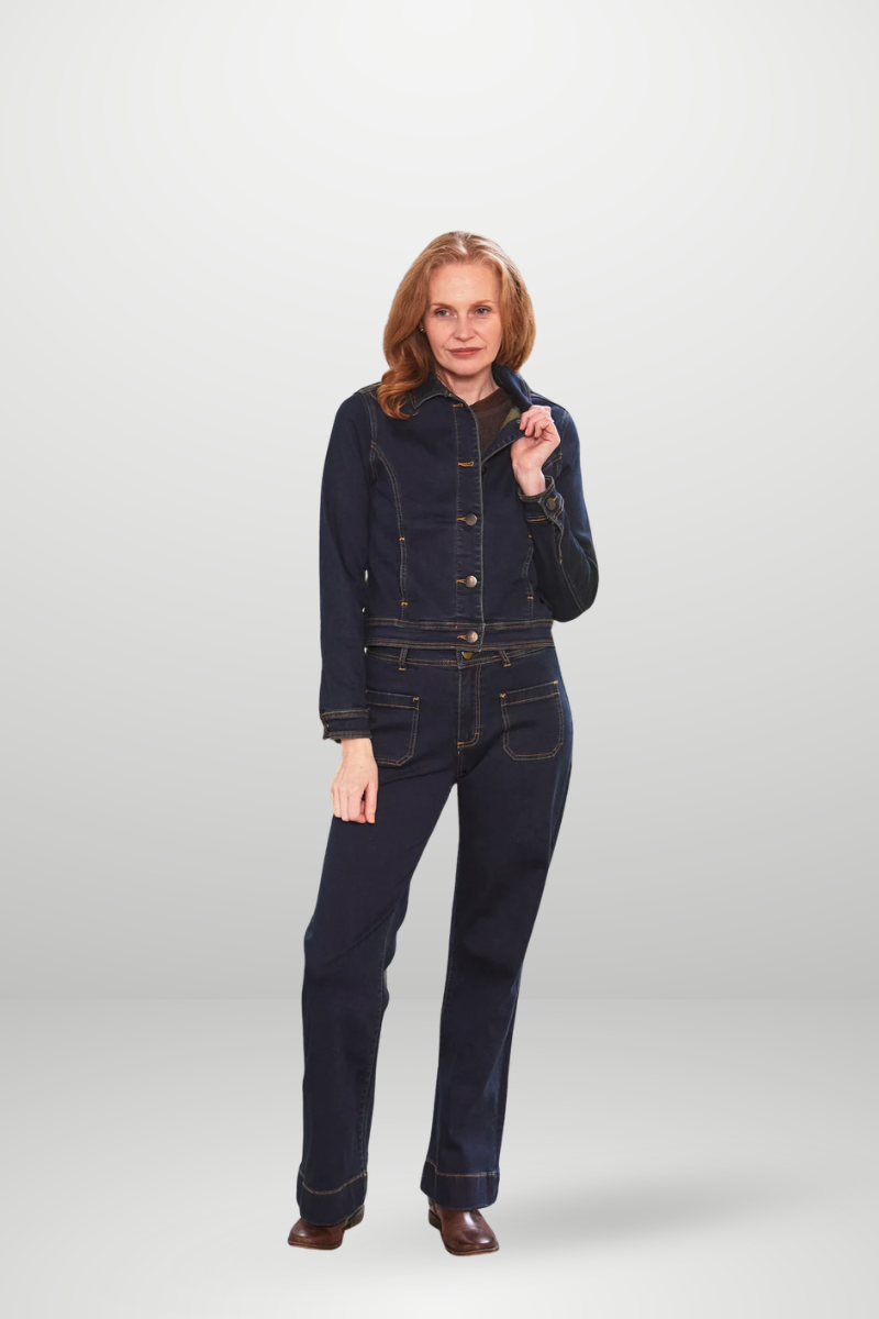 Woman wearing a dark denim jumpsuit on a white background