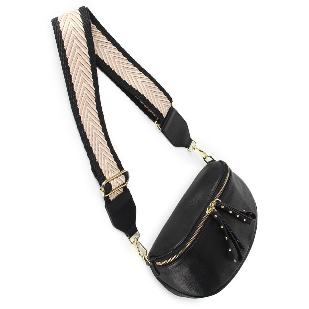 The Obsessed Bag is crafted in soft black leather with gold hardware, featuring a wide detachable strap and secure zip details, available at Ivy Vibe.

