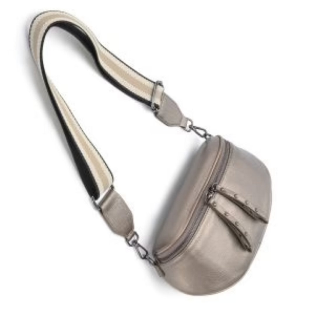 The Obsessed Bag is crafted in soft bronze leather with gunmetal hardware, featuring a wide detachable strap and secure zip details, available at Ivy Vibe.
