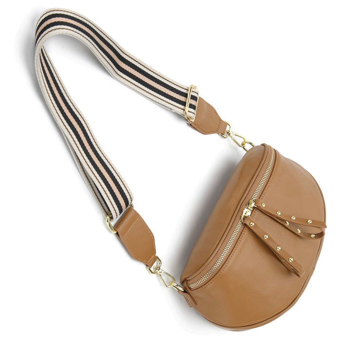 The Obsessed Bag is crafted in soft camel leather with gold hardware, featuring a wide detachable strap and secure zip details, available at Ivy Vibe.
