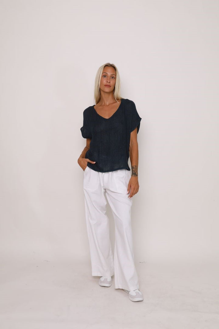 Front view of the Paris Top in black, displayed at Ivy Vibe, featuring a relaxed fit, V-neckline, and short sleeves made from handwoven midweight cotton.