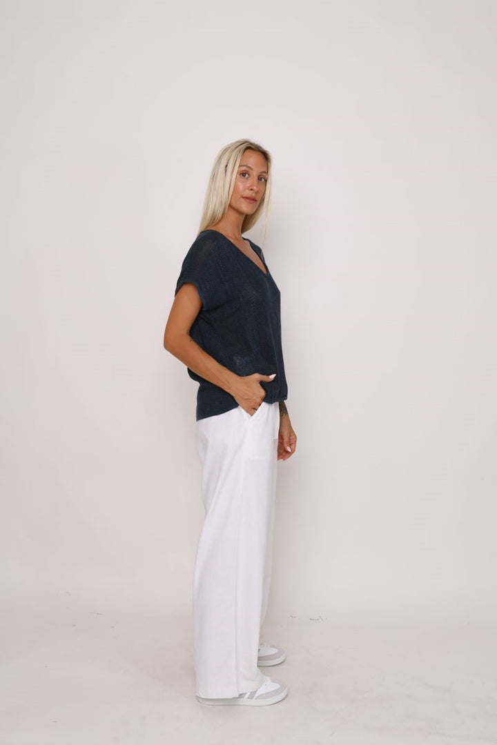 Side view of the Paris Top in black, showcased at Ivy Vibe, highlighting its relaxed fit, V-neckline, and handwoven midweight cotton fabric.