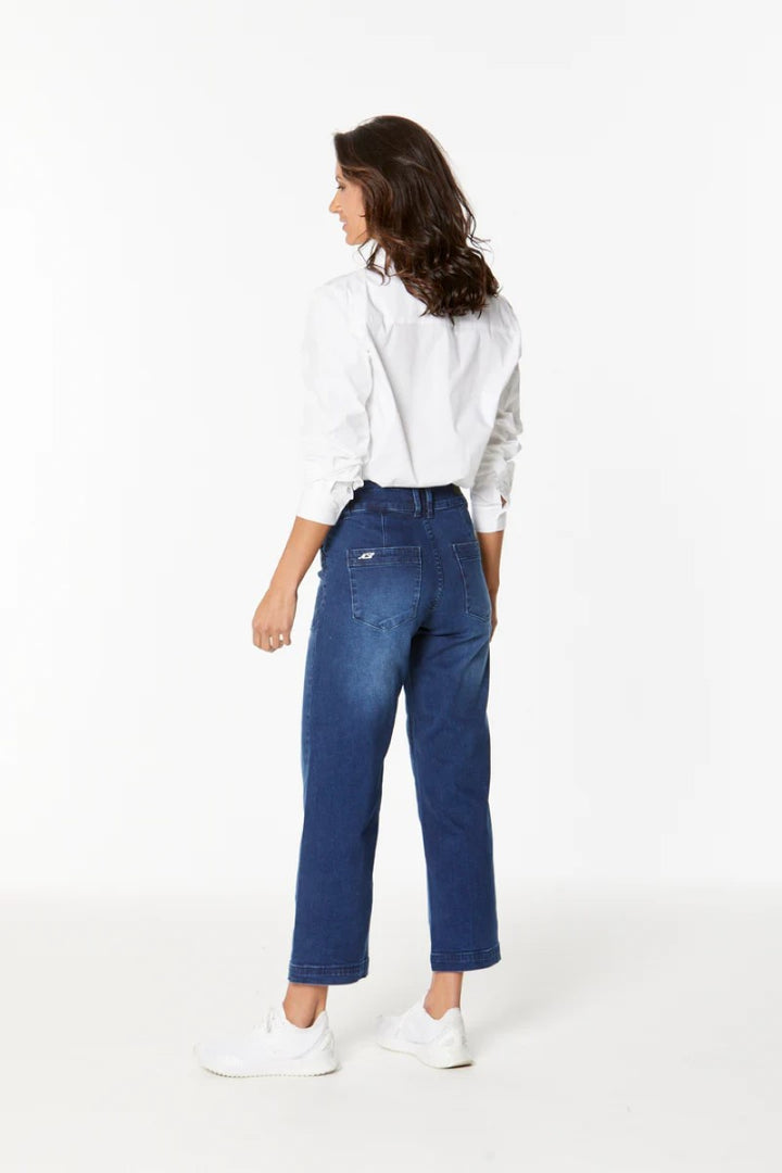 Woman wearing blue jeans and a white shirt on a white background