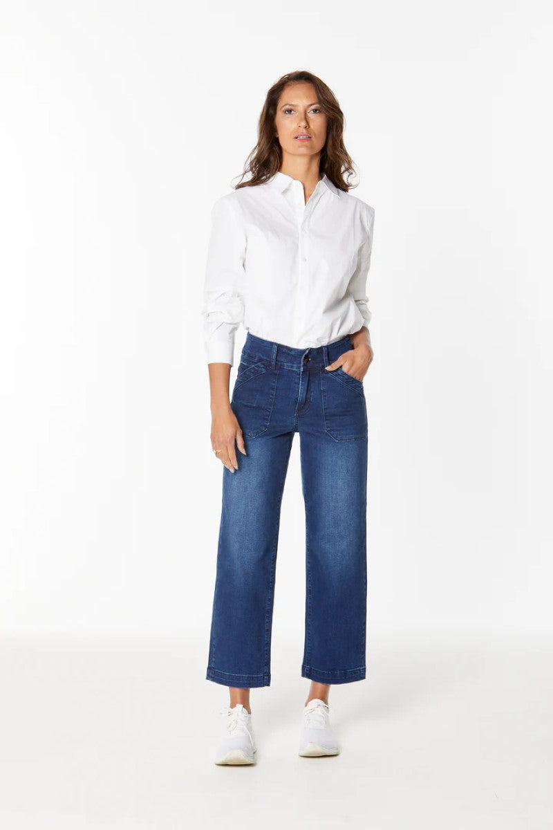 Woman wearing a white shirt and blue jeans on a white background