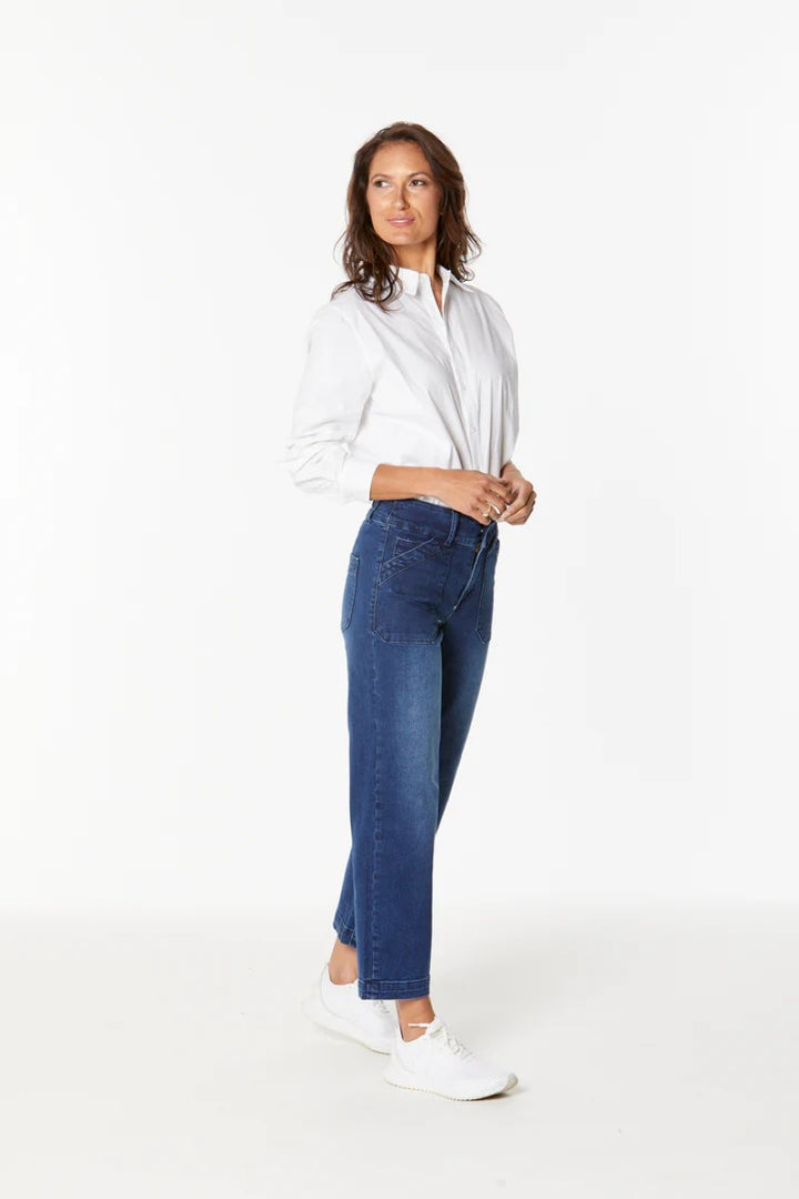 Woman wearing a white shirt and blue jeans on a white background