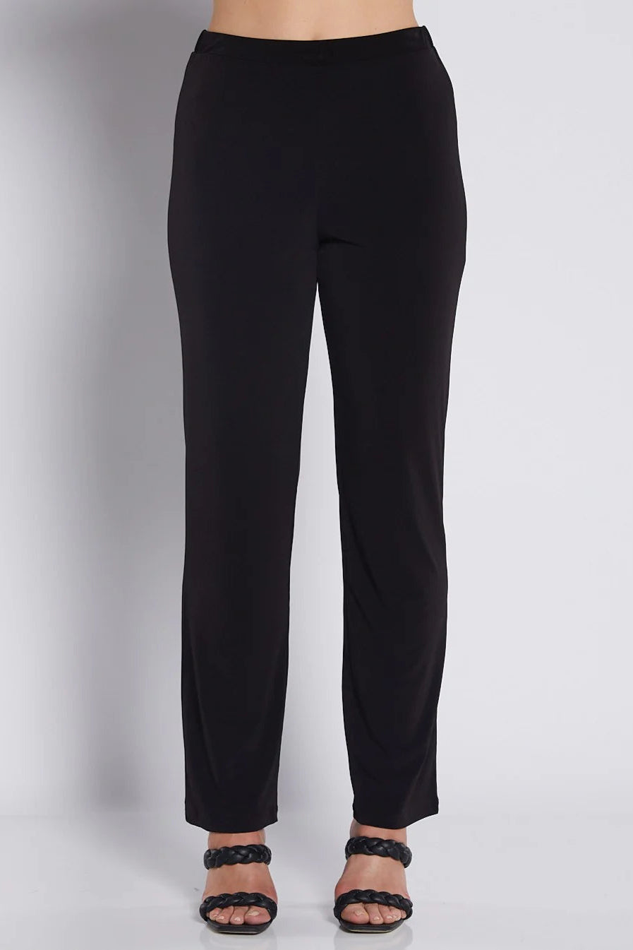 Black pants worn by a person on a plain background