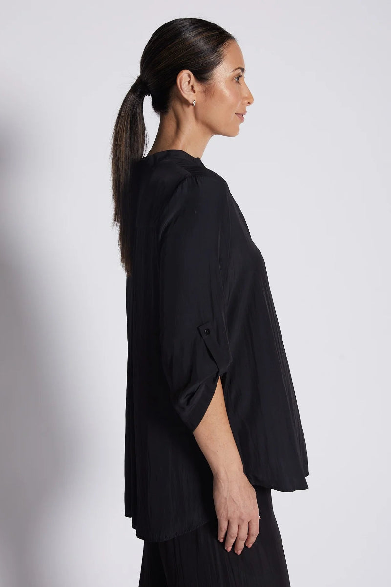 Woman wearing a black outfit against a white background
